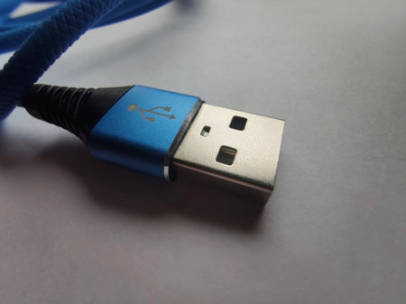 Close-up of a USB cable on a Light Background. Blue USB Cable for Smartphone, on a White Background....