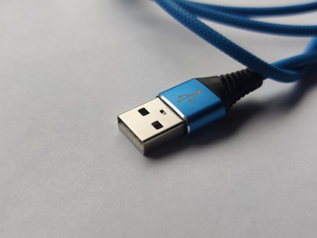 Close-up of a USB cable on a Light Background. Blue USB Cable for Smartphone, on a White Background....