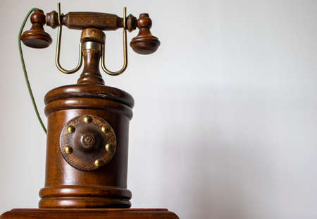 Wooden, old telephone on a light background.の写真素材