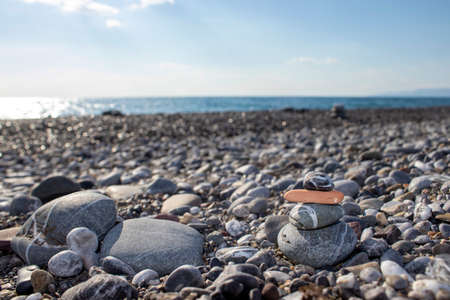 Pyramid stones balance on the sand of the beach. Object on the background of the sea. Calm concept.の写真素材