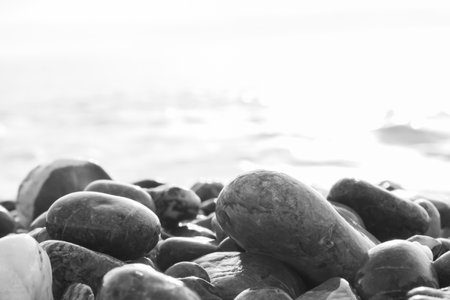 Wide shot of Stones on the Beach of Calabria, South of Italy in Summer While on Vacation. Gray Cobblestones of the Beach with the Sea in the Background.の写真素材
