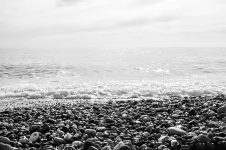 Pebble Stones. Pebbles on the Shore Close-up in the Blurry Light of the Sea with the Rays of the Sun...