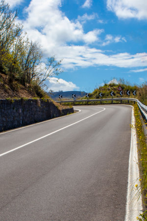 Winding Road Sign in the Woods and Mountains. Curve Road Sign on Down Hill.の写真素材