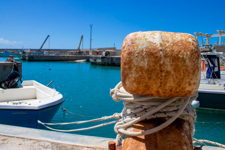 Old Mooring Bollard with rope Tied on Pier. Boat Tied With a Rope on a Mooring.の写真素材