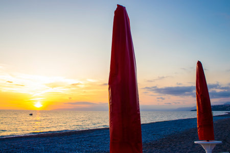 Beach Coast in the Evening. Strong Waves of the White Sea, Storm, Umbrellas are Closed. A Storm is Approaching the Coast.の写真素材