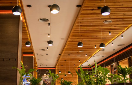 Illuminated Room in a Cafe. Brown Wooden Ceilings With Hanging Modern Lamps in a Cafe or Restaurant.の写真素材
