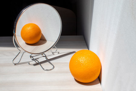 Fresh and Delicious Orange is Reflected in the Mirror. Fresh Fruit in a Mirror Image.