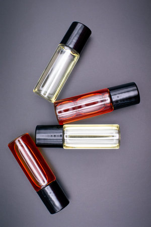 Bottles of perfume or perfumed oil on a dark background. Copy space for your brand.