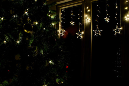 Festive Christmas Decorations With Twinkling Lights and a Beautifully Adorned Tree in a Cozy Indoor...