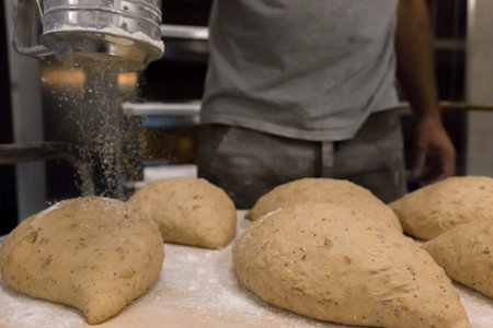 Pouring flour to the bread loafs before entering them in the oven