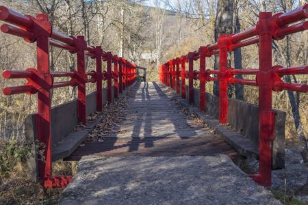 Lonely red bridge over the riverの写真素材