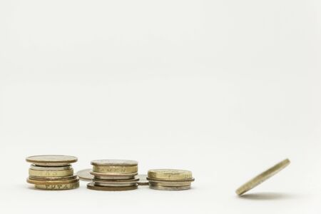 Three piles of coins and a spinning coinの写真素材