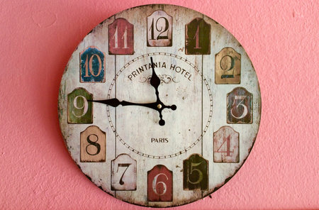 Wood clock on a pinky wall