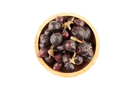 Top view of Syzygium cumini, black plum, jamun or Syzygium cumini in wooden bowl isolated on white backgroundの写真素材