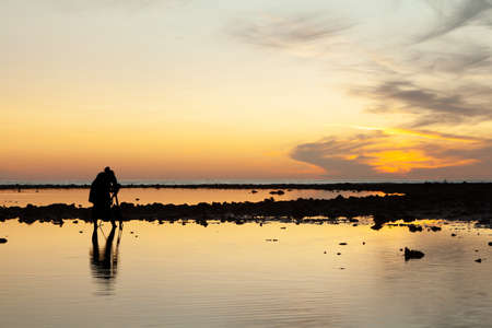 Silhouette of the woman raise her hand in the evening at Pakarang beach, Phang Nga, Thailandの写真素材