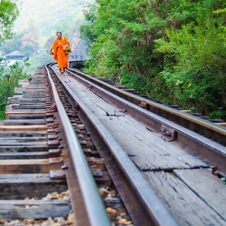 Kanchanaburi, Thailand - March 6, 2011 : Monks walk on The Death railway , Kanchanaburi , Thailandのeditorial素材