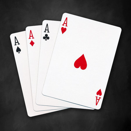 A winning poker hand of four aces playing cards suits on black background