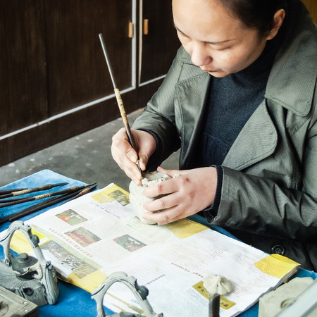 ZHOUZHUANG, SHANGHAI - April 11, 2011 : Chinese woman artisan is making tea pot at Zhouzhuang, the ancient water village is near Shanghai.のeditorial素材