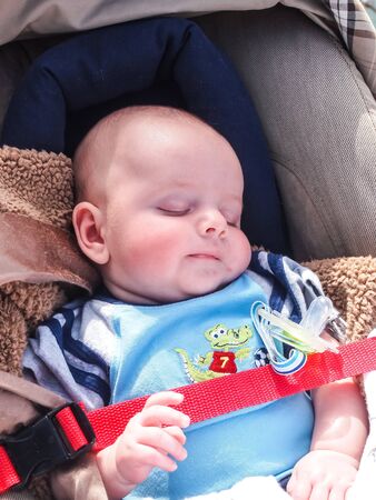 CALIFORNIA, UNITED STATES - April 1, 2012 : A sweet baby is sleeping in a baby cart in the parkのeditorial素材