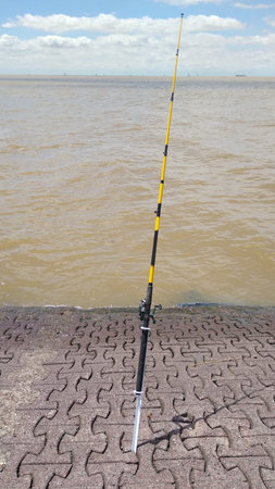 Yellow fishing rod by the widest river in the world, the Rio de la Plata river.