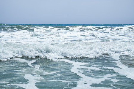 The surging waves of the Mediterranean on the beautiful beach Valencia in the summer sunny day.の写真素材