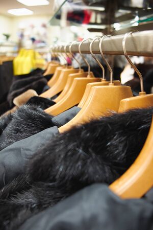 Hangers with coats and jackets in a clothing store.の写真素材