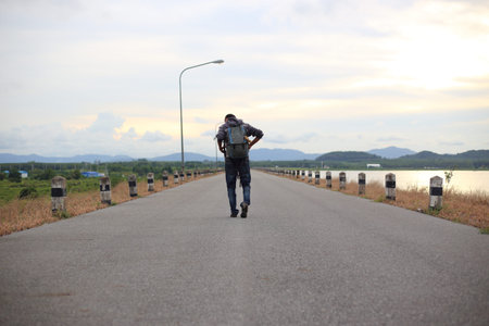 Man walking on road of dam in Pra Sae Reservoir at Rayong, Thailandの写真素材