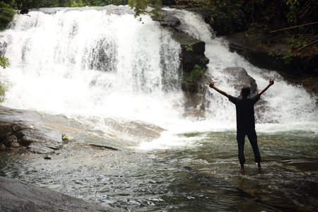 Man standing at Khao Cha Mao Waterfall in Rayong Thailandの写真素材