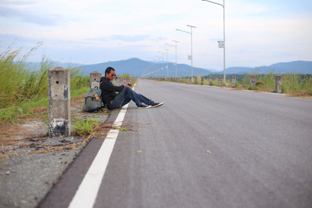 Men sit on the street in Rayong, Thailandの写真素材