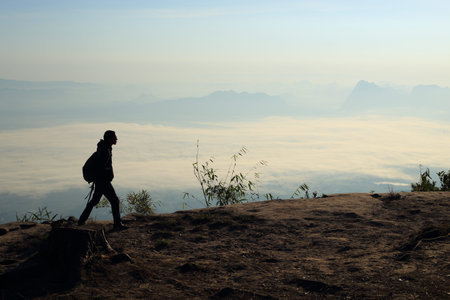 Man walking on the cliffs and mist at Phu Kradung National Park,Thailand