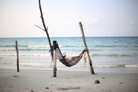 Woman sleeping in a hammock at the beachの写真素材
