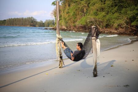 Man sleeping in a hammock at the beachの写真素材