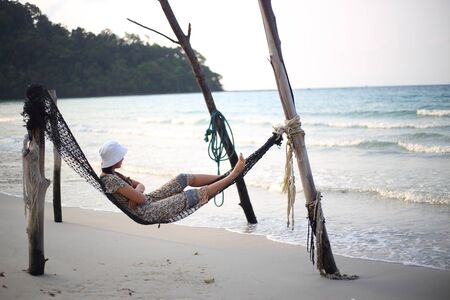 Woman sleeping in a hammock at the beachの写真素材