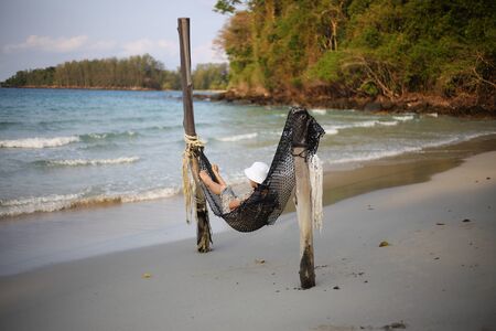 Woman sleeping in a hammock at the beachの写真素材