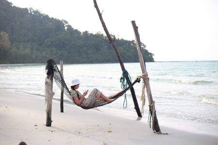 Woman sleeping in a hammock at the beachの写真素材