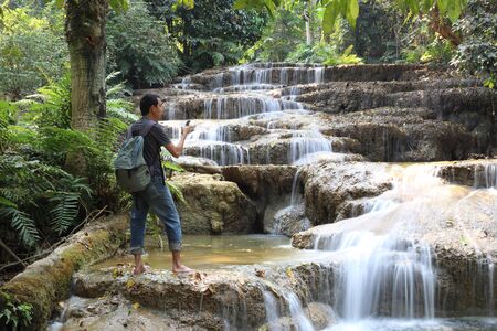 Man standing at Mae Kae 2 Waterfall or Kaofu Waterfall in Lampang Province, Thailandの写真素材