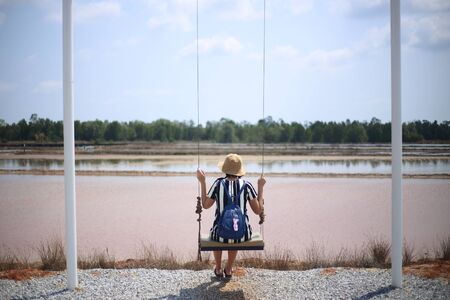 Woman swings on the waterfrontの写真素材