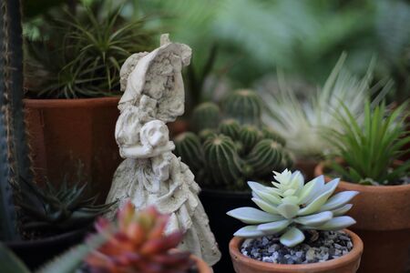 Statue of a woman holding a dog in the gardenの写真素材