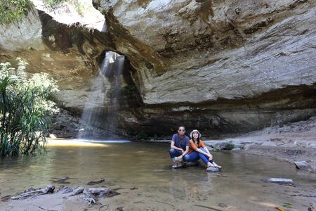 Women and men sitting at Saeng Chan Waterfall at Pha Taem National Park, Ubon Ratchathani, Thailandの写真素材