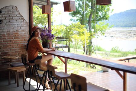 A woman watching the river view through the glassの写真素材