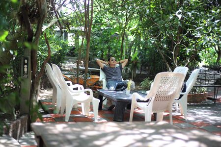 A man resting on a chair in the gardenの写真素材