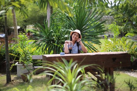 Woman sitting in garden with green plantsの写真素材