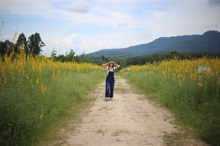 A woman standing in the crotalaria juncea field in Rayong, Thailandの写真素材