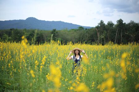 A woman standing in the crotalaria juncea field in Rayong, Thailandの写真素材