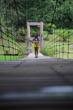 Women on a wooden suspension bridge in Khlong Wang Chao Kamphaeng Phet National Park, Thailandの写真素材