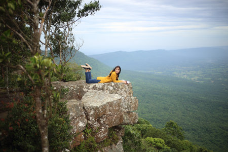 Woman lie down on the cliff at Mor Hin Khao National Park in Chaiyaphum, Thailand