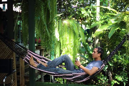 Man sitting in garden with green plantsの写真素材