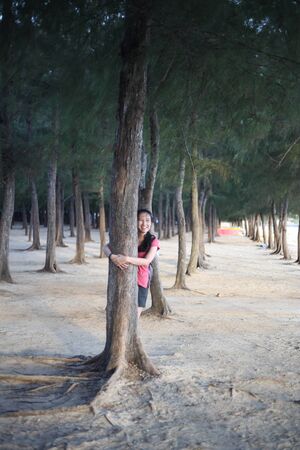 A woman standing on a pine forest by the beachの写真素材
