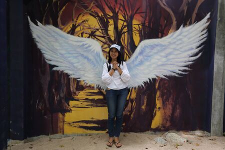 Woman and drawing of wings on the wallの写真素材