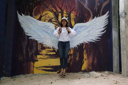 Woman and drawing of wings on the wallの写真素材
